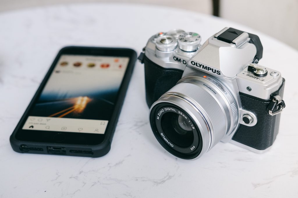 Kamera neben Smartphone mit Instagram 
